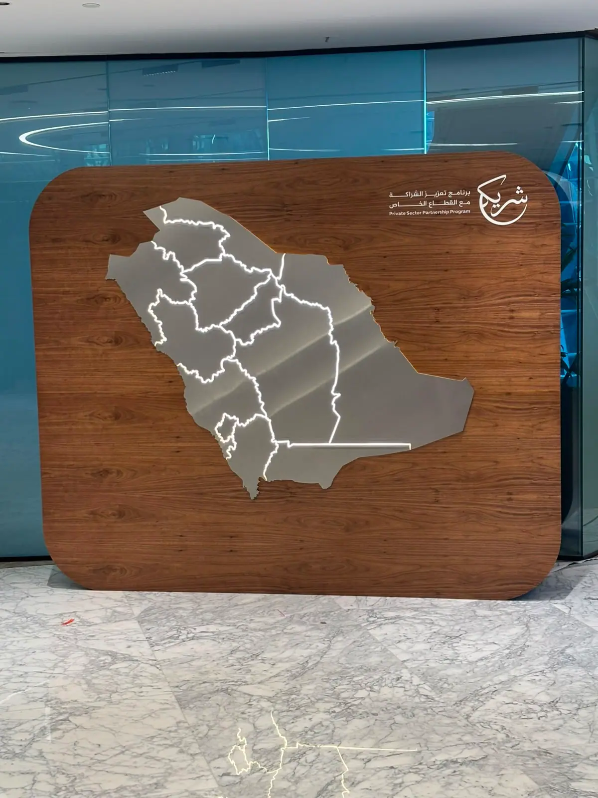 Shareek — Illuminated Map Wall — Brushed metal against the walnut grain
